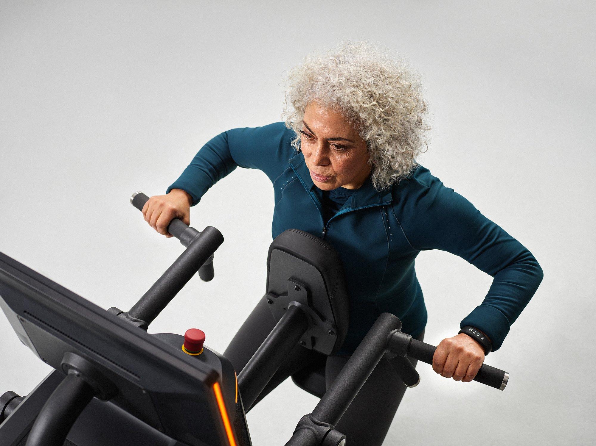 Een vrouw traint geconcentreerd op een EGYM-krachtapparaat